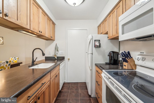 kitchen featuring white appliances, dark tile patterned flooring, dark countertops, and a sink