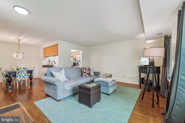 living room with baseboards, wood finished floors, and visible vents