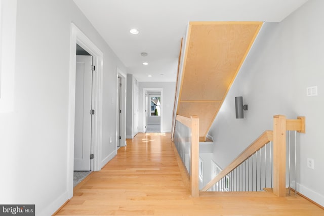 hall featuring recessed lighting, an upstairs landing, wood finished floors, and baseboards