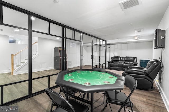 rec room with visible vents, baseboards, and wood finished floors