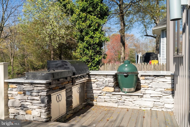 view of patio / terrace featuring grilling area, fence, and exterior kitchen