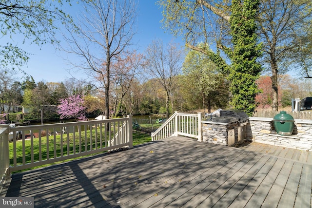 wooden terrace featuring exterior kitchen and a grill