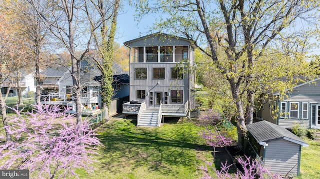 back of property with a deck and a lawn