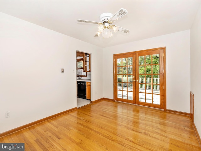 spare room with baseboards, ceiling fan, french doors, and light wood-type flooring