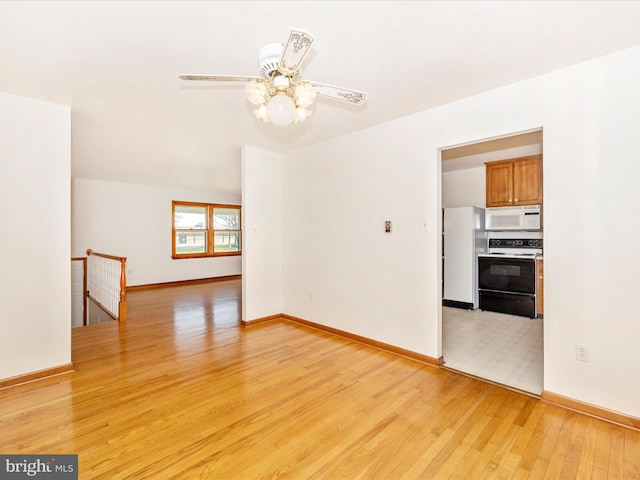 unfurnished room featuring light wood-type flooring, baseboards, and ceiling fan