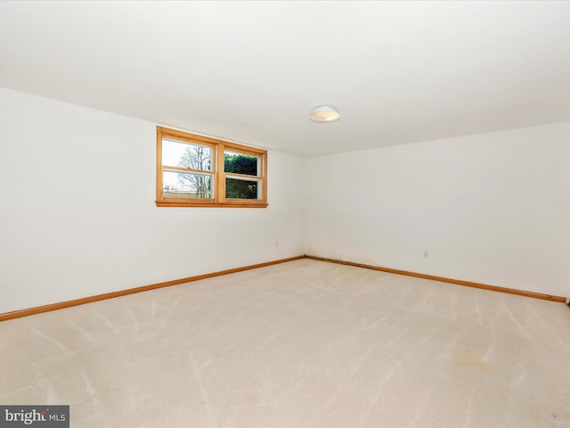 empty room with baseboards and light colored carpet