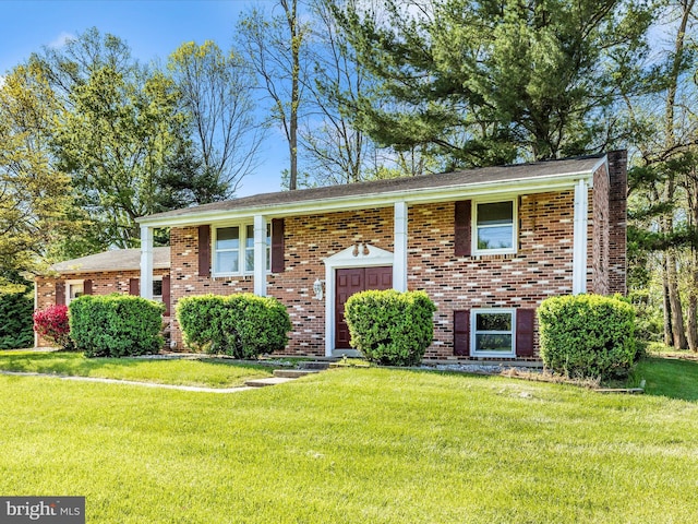 bi-level home featuring brick siding and a front lawn