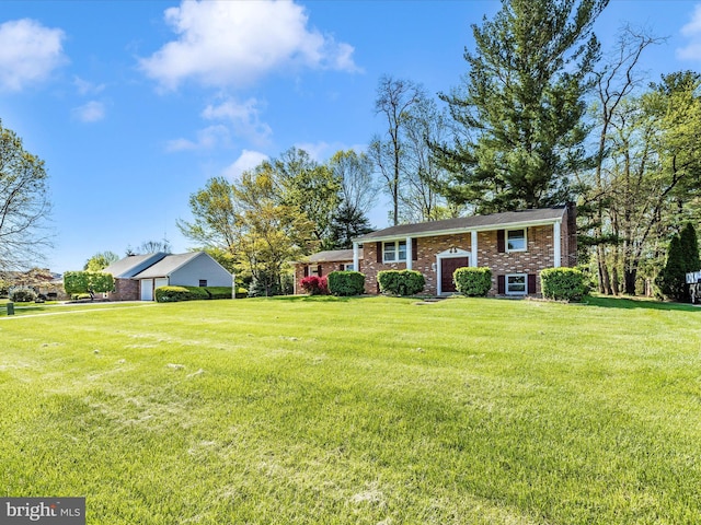 split foyer home featuring brick siding and a front yard