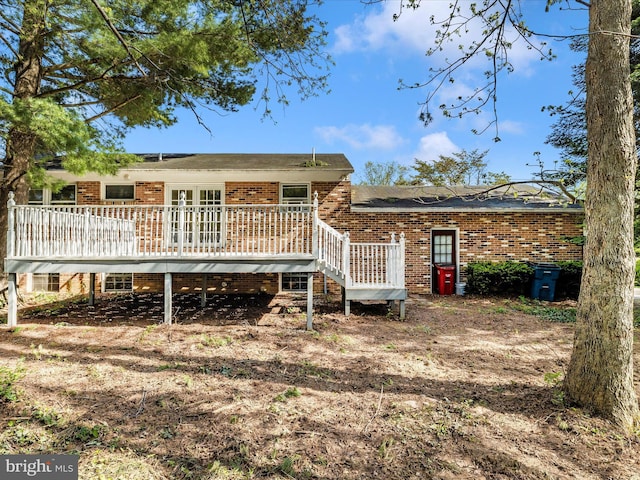 back of property featuring brick siding and a wooden deck