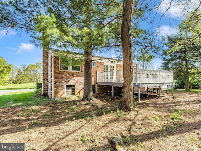 rear view of property with brick siding and a wooden deck