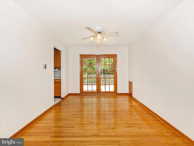 unfurnished room featuring baseboards, ceiling fan, french doors, and light wood-style floors