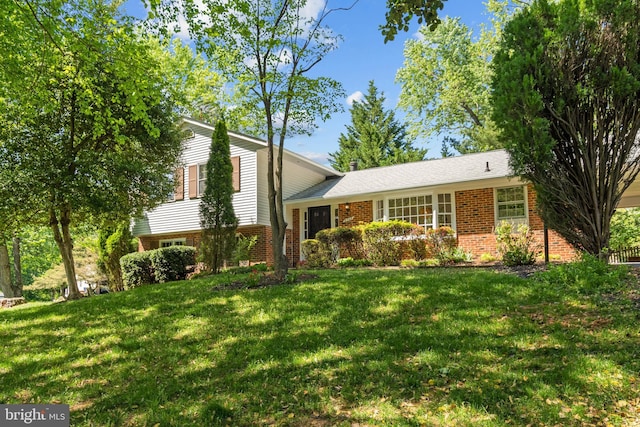 split level home featuring brick siding and a front lawn