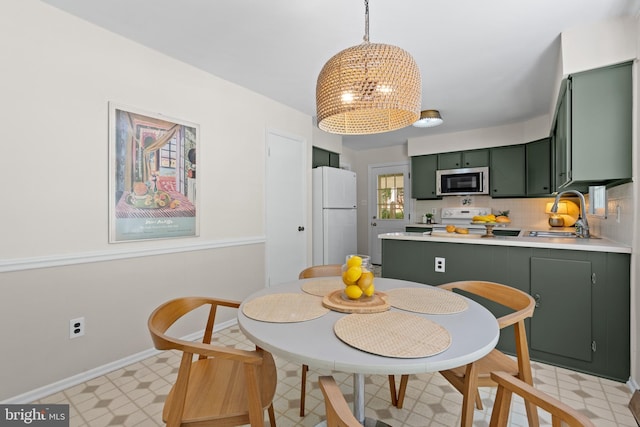 dining space featuring light floors, baseboards, and a notable chandelier