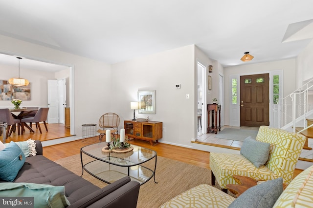 living area with stairway and wood finished floors