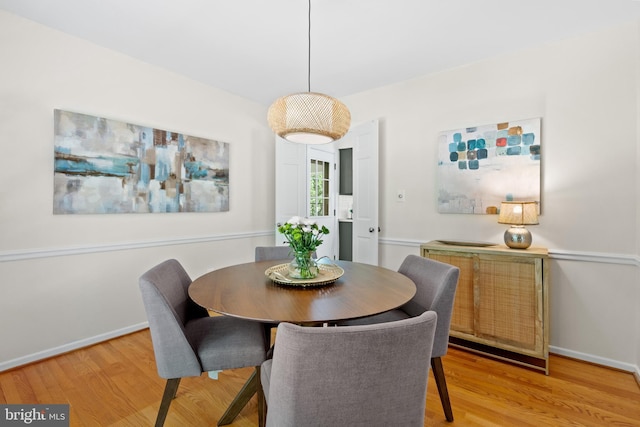 dining room with baseboards and light wood-style flooring