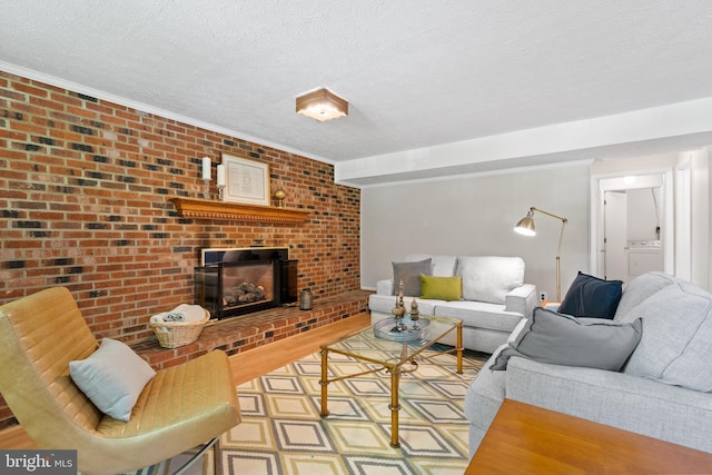 living room featuring washer / dryer, a fireplace, and a textured ceiling