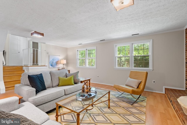 living area featuring baseboards, a textured ceiling, and light wood-style flooring