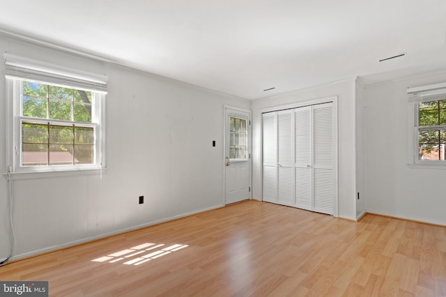 unfurnished bedroom with baseboards, wood finished floors, and a closet