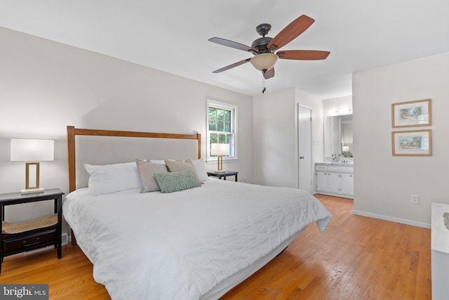 bedroom featuring connected bathroom, a ceiling fan, baseboards, and light wood finished floors