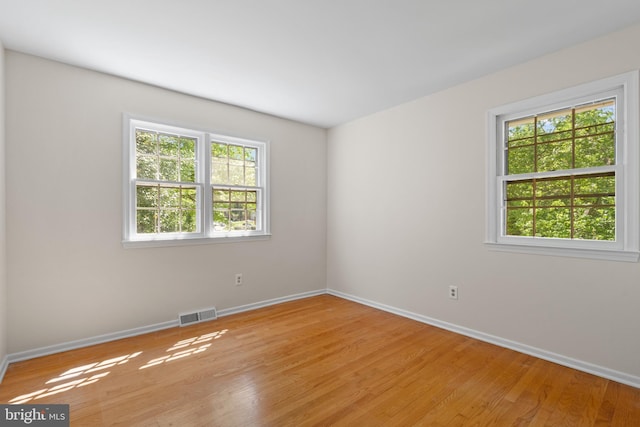 spare room featuring visible vents, baseboards, and light wood-type flooring