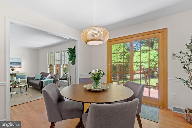 dining room featuring baseboards, light wood-style flooring, and visible vents