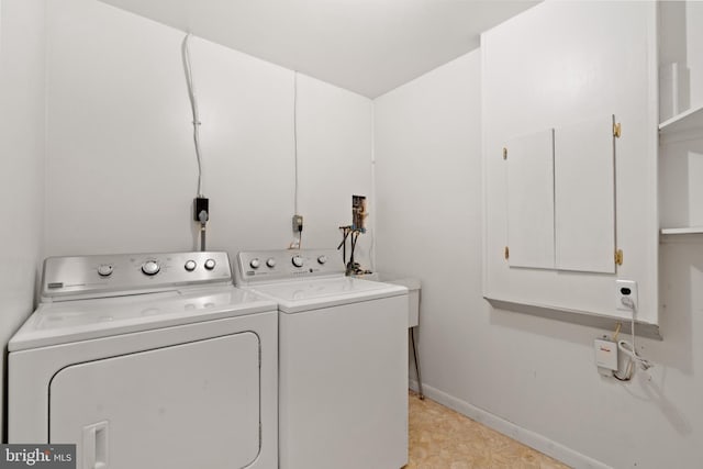 laundry area with independent washer and dryer and baseboards