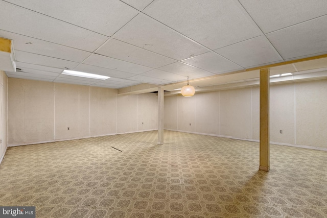 finished basement featuring baseboards and a drop ceiling
