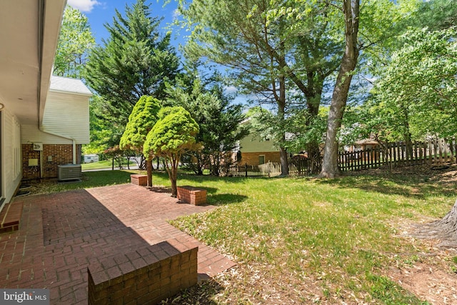 view of yard featuring central AC, fence, and a patio area