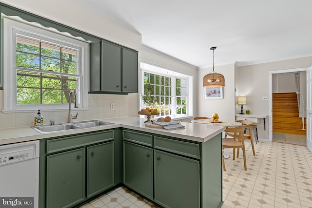 kitchen with dishwasher, a peninsula, a sink, and green cabinets