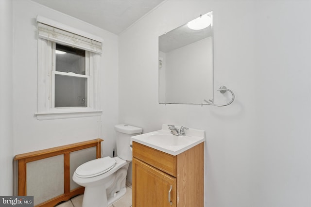 bathroom with toilet, vanity, and tile patterned flooring