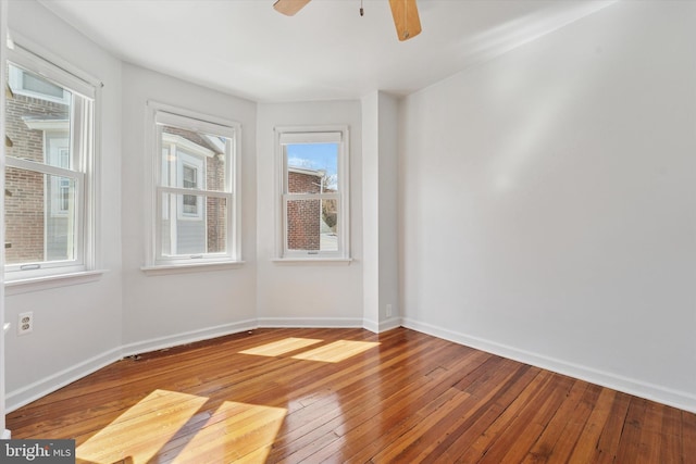unfurnished room featuring baseboards, a ceiling fan, and hardwood / wood-style floors