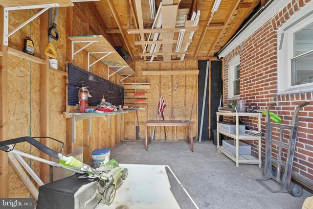 misc room featuring unfinished concrete flooring and a workshop area