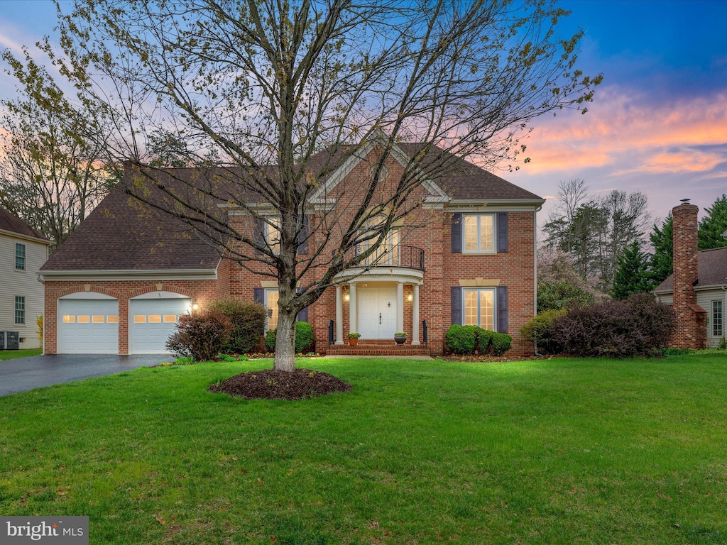 15154 Wetherburn Dr, Centreville, VA 20120 - view of front of house with aphalt driveway, brick siding, a front lawn, a balcony, and an attached garage