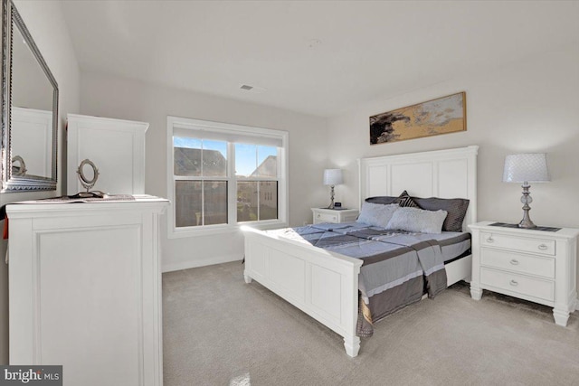 bedroom with baseboards, light colored carpet, and visible vents