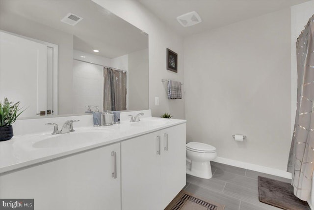 full bathroom featuring visible vents, a sink, double vanity, and toilet