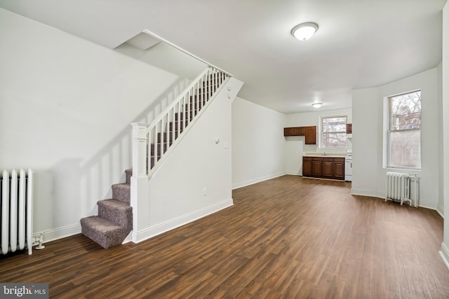 4914 N Smedley St, Philadelphia, PA 19141 - unfurnished living room with radiator heating unit, dark wood-style floors, and stairs