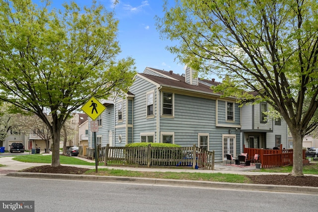view of front of home featuring a chimney and fence