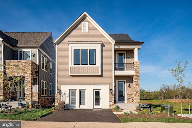 view of front of house with a balcony and stone siding