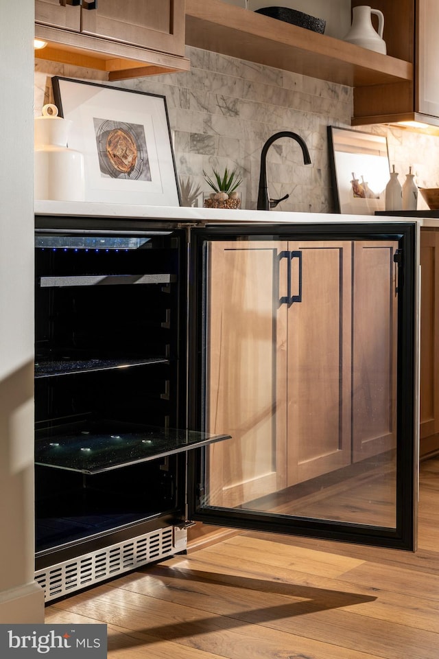 bar with tasteful backsplash, wine cooler, and wood finished floors