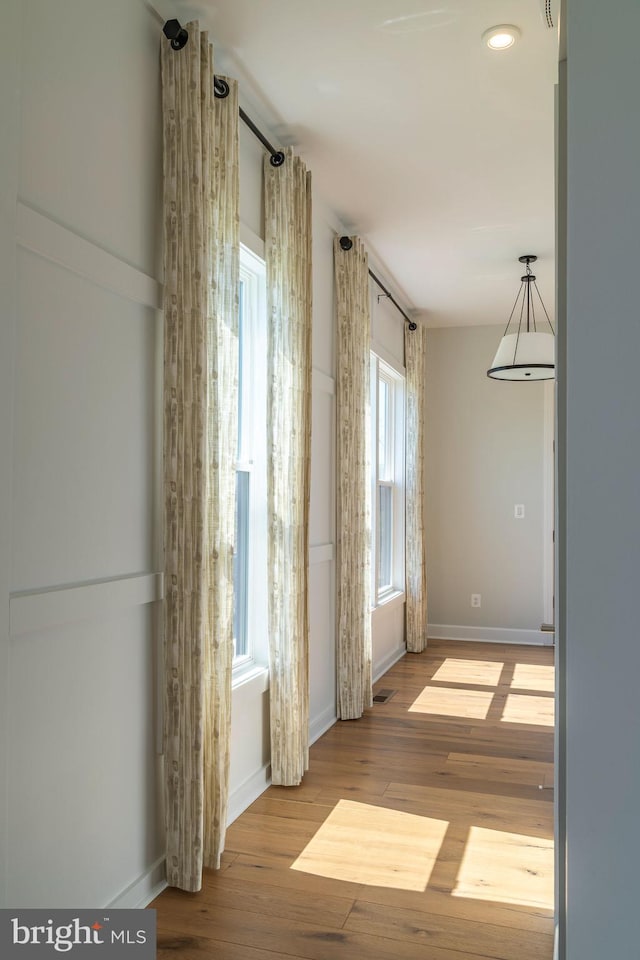 interior space with visible vents, baseboards, and wood finished floors