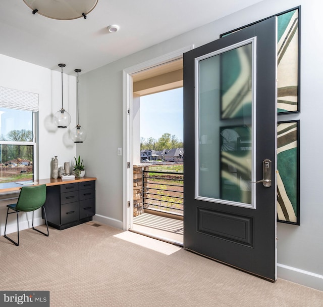 doorway to outside with light colored carpet and baseboards