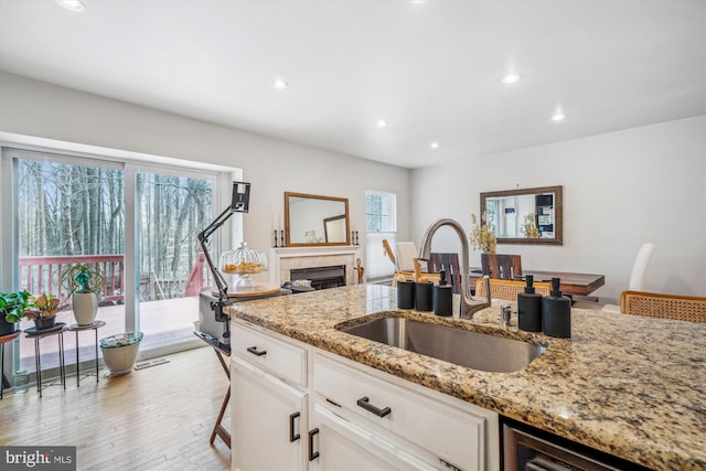 3 Casino Ct, Silver Spring, MD 20906 - kitchen with light stone counters, recessed lighting, light wood-style flooring, white cabinetry, and a sink