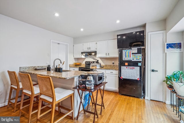 3 Casino Ct, Silver Spring, MD 20906 - kitchen with white cabinets, under cabinet range hood, black appliances, light wood finished floors, and a sink