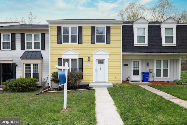 multi unit property featuring a front yard and a shingled roof