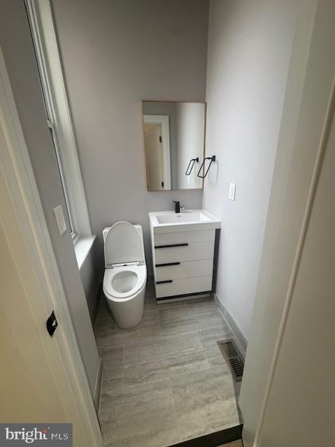 1809 Christian St, Philadelphia, PA 19146 - bathroom with toilet, baseboards, visible vents, and vanity