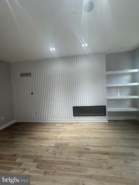 1809 Christian St, Philadelphia, PA 19146 - additional living space with baseboards, a fireplace, wood finished floors, and visible vents