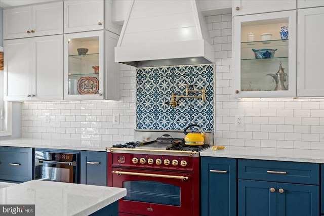 4935 New Hampshire Ave NW, Washington, DC 20011 - kitchen featuring white cabinets, range with gas stovetop, premium range hood, and blue cabinets