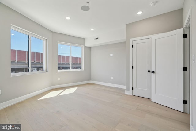 unfurnished bedroom with light wood-type flooring, baseboards, visible vents, and recessed lighting