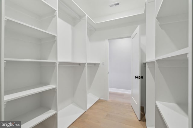 walk in closet with visible vents and wood finished floors