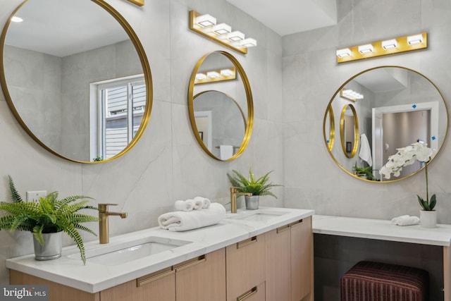 full bath featuring a sink, tile walls, and double vanity